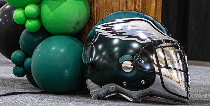 Philadelphia Eagles helmet with green balloons at a festive party.