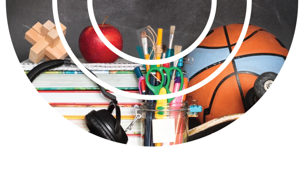 Education and sports collide in vibrant still life — books, apple, basketball, and pens.