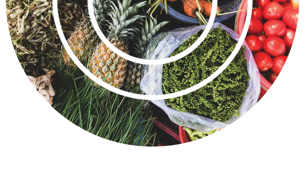 Fresh tropical fruits and leafy greens arranged in a vibrant market display.