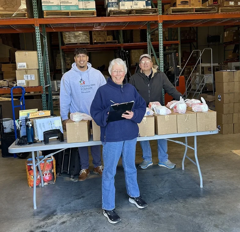Team packing and distributing food supplies at a warehouse distribution center.
